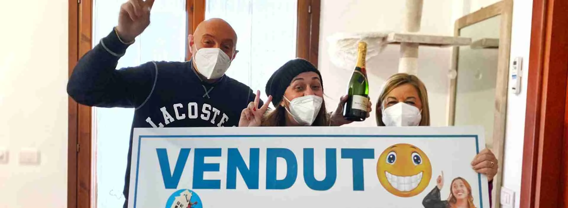 Clienti festeggiano con il cartello VENDUTO
