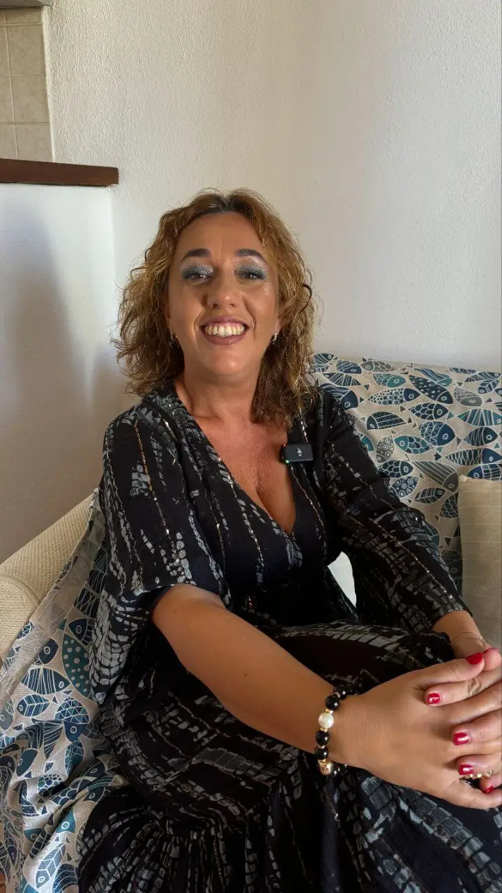 Enrica Mazzei sorridente, seduta sul divano