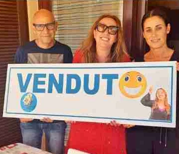 Clienti di Enrica con il cartello VENDUTO